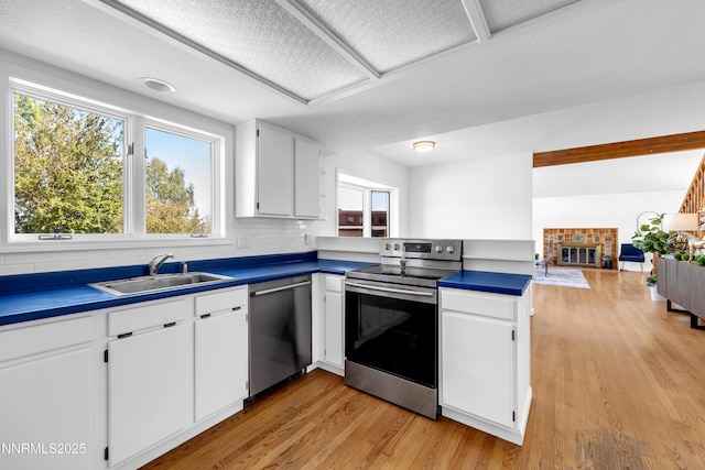 4360 Slide Mountain Cir, Reno, NV 89511 - kitchen with stainless steel appliances, a sink, light wood-type flooring, decorative backsplash, and white cabinets