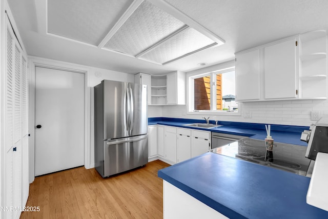 4360 Slide Mountain Cir, Reno, NV 89511 - kitchen with open shelves, freestanding refrigerator, a sink, light wood-style floors, and backsplash