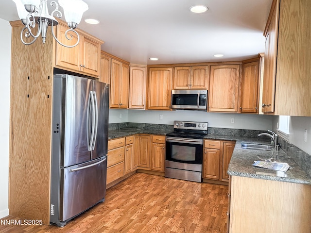 604 W Winnie Ln, Carson City, NV 89703 - kitchen with stainless steel appliances, a sink, light wood-style floors, recessed lighting, and a chandelier