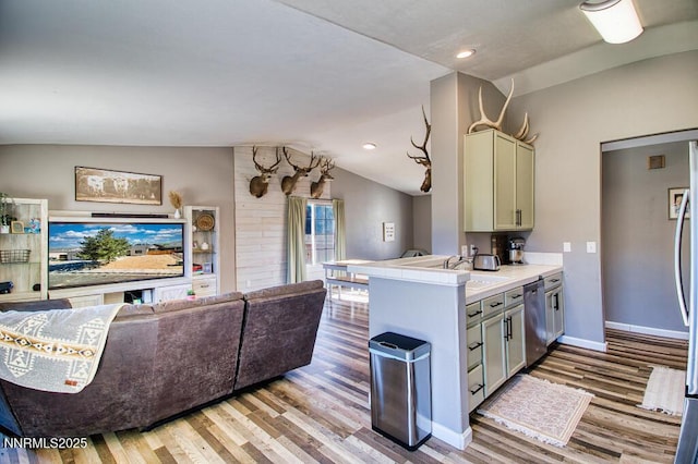 1563 Maria Ct, Fernley, NV 89408 - kitchen featuring stainless steel dishwasher, lofted ceiling, light wood-style flooring, open floor plan, and baseboards