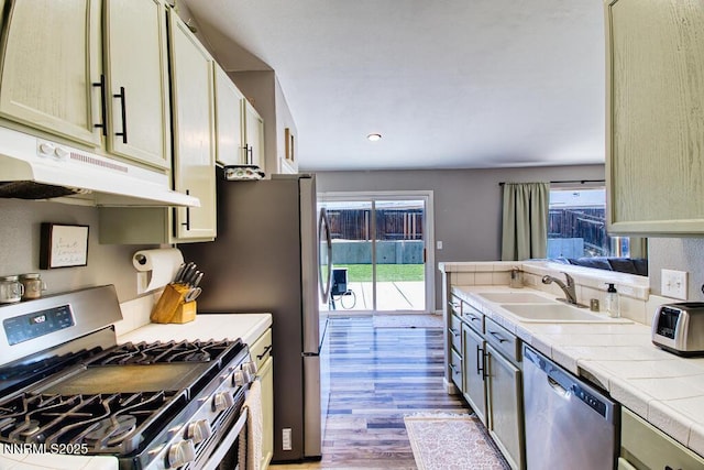 1563 Maria Ct, Fernley, NV 89408 - kitchen featuring stainless steel appliances, under cabinet range hood, wood finished floors, tile countertops, and a sink