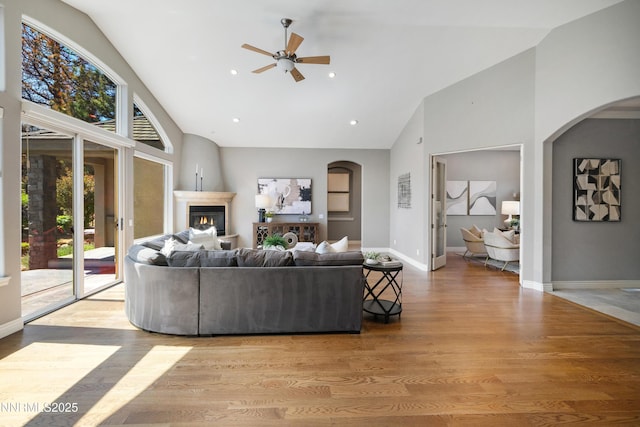 193 N Argyle Ct, Reno, NV 89511 - living area featuring high vaulted ceiling, arched walkways, ceiling fan, wood finished floors, and a fireplace