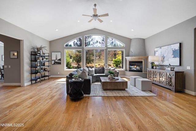 193 N Argyle Ct, Reno, NV 89511 - living area featuring a ceiling fan, light wood finished floors, a large fireplace, vaulted ceiling, and baseboards