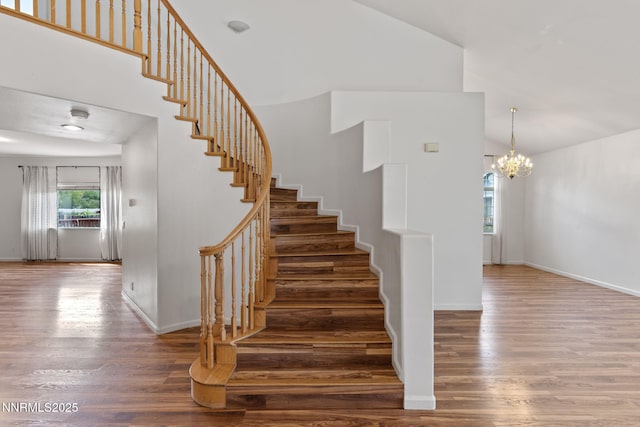 3095 Fairwood Dr, Reno, NV 89502 - staircase featuring wood finished floors, a chandelier, high vaulted ceiling, and baseboards