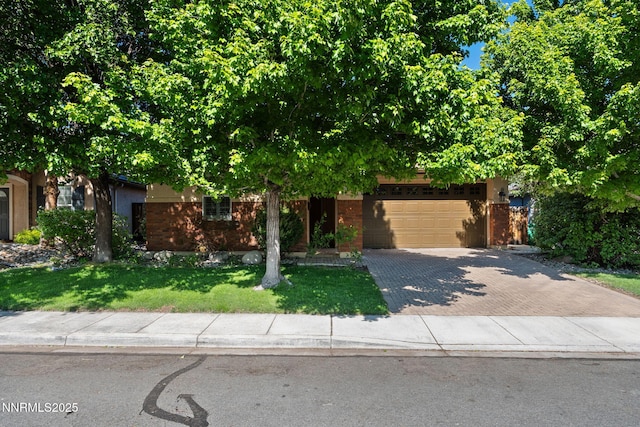 11285 Messina Way, Reno, NV 89521 - obstructed view of property featuring decorative driveway, an attached garage, a front lawn, and brick siding