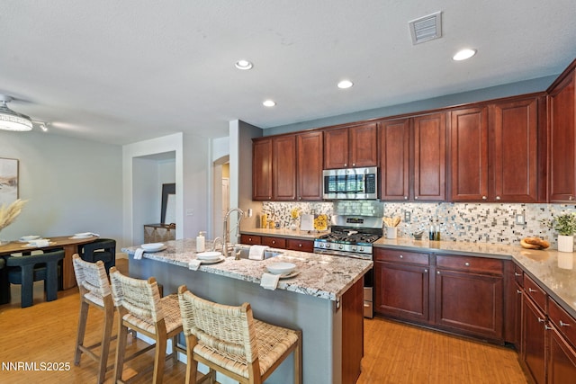 11285 Messina Way, Reno, NV 89521 - kitchen featuring stainless steel appliances, light wood-style flooring, tasteful backsplash, a sink, and recessed lighting