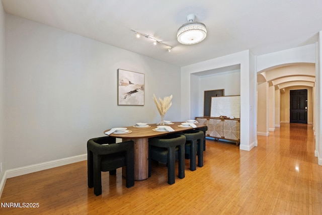 11285 Messina Way, Reno, NV 89521 - dining room with arched walkways, track lighting, baseboards, and light wood-type flooring
