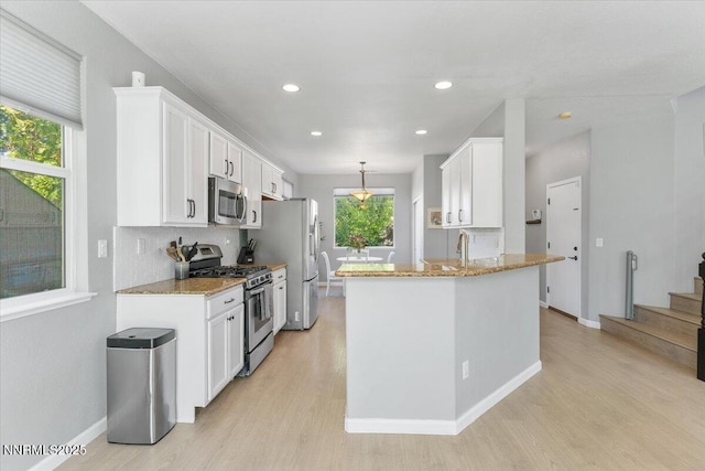 2349 Dodge Dr, Sparks, NV 89436 - kitchen with appliances with stainless steel finishes, light wood finished floors, white cabinets, light stone countertops, and recessed lighting