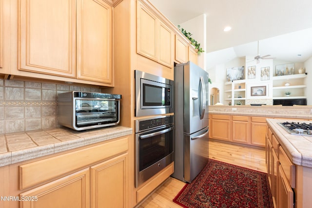 1601 Jones St, Minden, NV 89423 - kitchen with appliances with stainless steel finishes, light brown cabinetry, light wood-type flooring, open floor plan, and vaulted ceiling