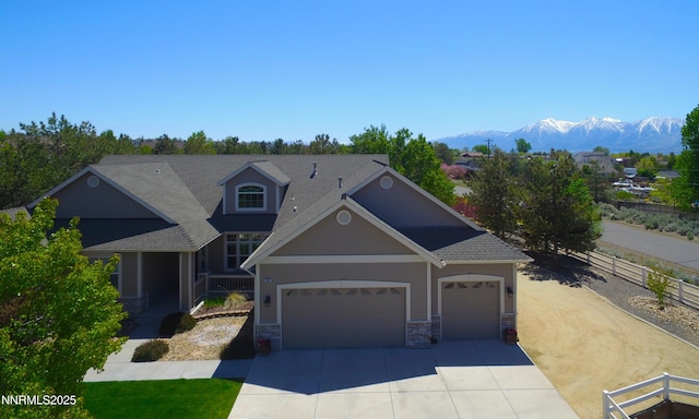 1601 Jones St, Minden, NV 89423 - view of front of house featuring driveway, stone siding, a garage, and a mountain view
