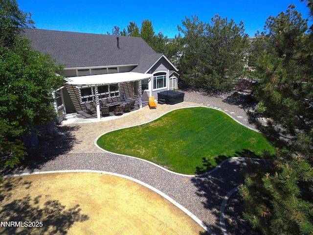 1601 Jones St, Minden, NV 89423 - rear view of property featuring a hot tub, a patio area, a lawn, and roof with shingles