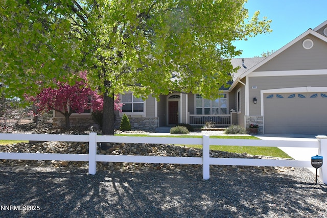 1601 Jones St, Minden, NV 89423 - view of property hidden behind natural elements with stone siding, a fenced front yard, and an attached garage