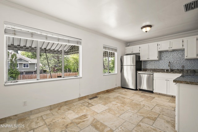 438 Glenmanor Dr, Reno, NV 89509 - kitchen featuring stainless steel appliances, stone tile floors, crown molding, white cabinetry, and decorative backsplash