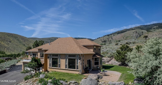 6 Canyon Dr, Carson City, NV 89703 - back of property with a mountain view, stucco siding, a shingled roof, and a yard