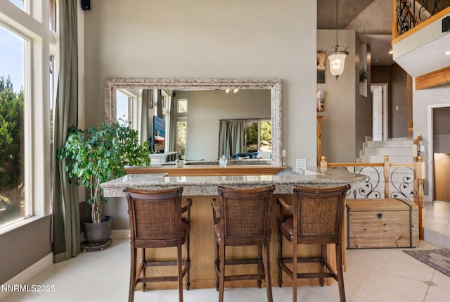 6 Canyon Dr, Carson City, NV 89703 - kitchen featuring healthy amount of natural light, light tile patterned floors, a towering ceiling, stone counters, and decorative light fixtures