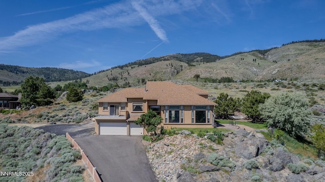 6 Canyon Dr, Carson City, NV 89703 - view of front of property featuring a garage, driveway, a mountain view, and stucco siding