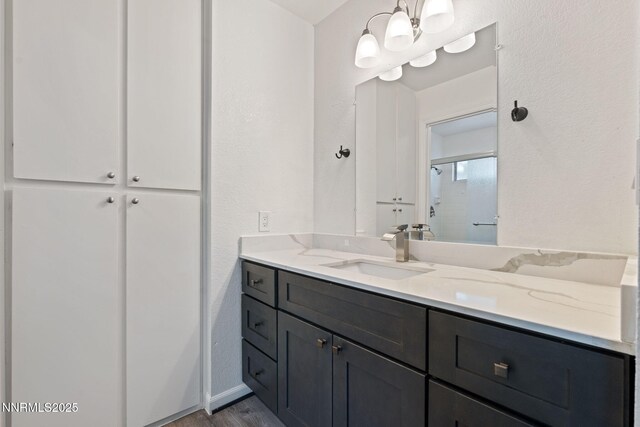 1821 Fargo Way, Sparks, NV 89434 - bathroom with vanity, wood finished floors, a shower with shower door, and a chandelier