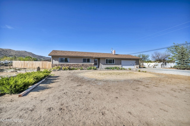 11815 Mistletoe St, Reno, NV 89506 - ranch-style home with a garage, a mountain view, a chimney, and stone siding
