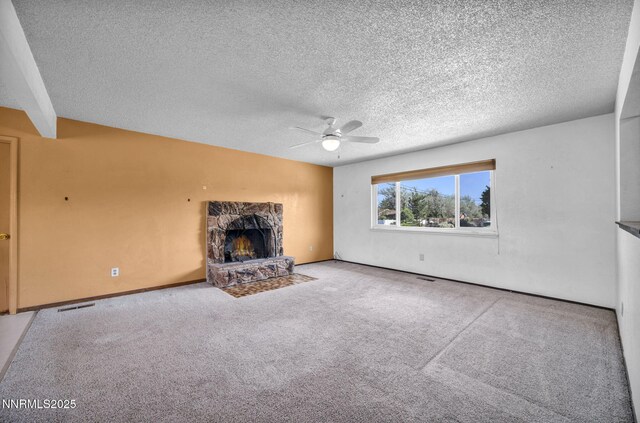 11815 Mistletoe St, Reno, NV 89506 - unfurnished living room featuring a ceiling fan, a stone fireplace, carpet floors, and a textured ceiling