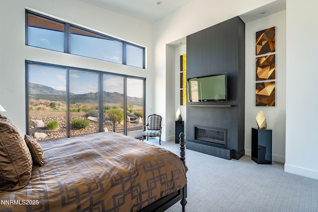 310 James Canyon Loop, Genoa, NV 89411 - bedroom featuring carpet floors, a glass covered fireplace, baseboards, and a towering ceiling