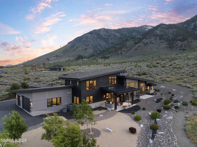 310 James Canyon Loop, Genoa, NV 89411 - back of house featuring a mountain view, a patio, and a garage