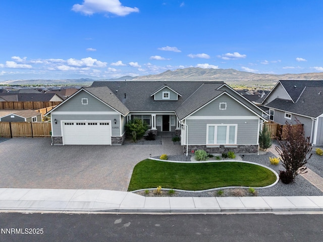 11621 Desert Shadow Dr, Sparks, NV 89441 - view of front of home featuring an attached garage, stone siding, decorative driveway, a mountain view, and a residential view