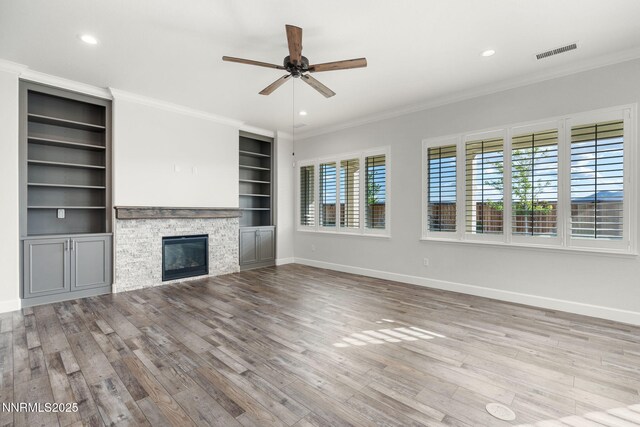 11621 Desert Shadow Dr, Sparks, NV 89441 - unfurnished living room with a ceiling fan, wood finished floors, ornamental molding, baseboards, and a stone fireplace