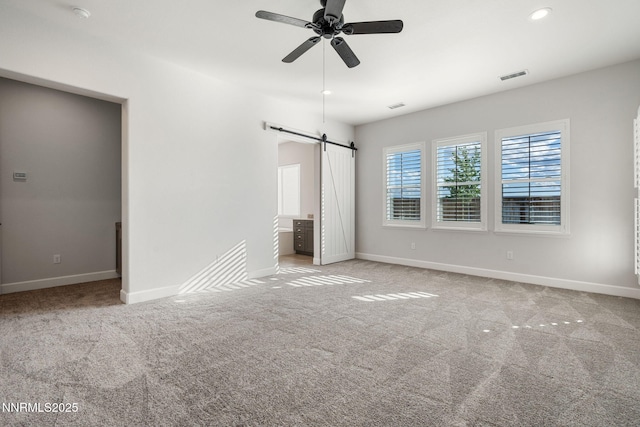 11621 Desert Shadow Dr, Sparks, NV 89441 - unfurnished bedroom featuring a barn door, carpet floors, baseboards, and ceiling fan