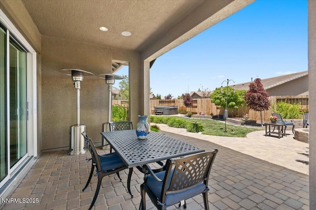 9822 Dyevera Ln, Reno, NV 89521 - fenced backyard featuring a hot tub, a patio, and outdoor dining space