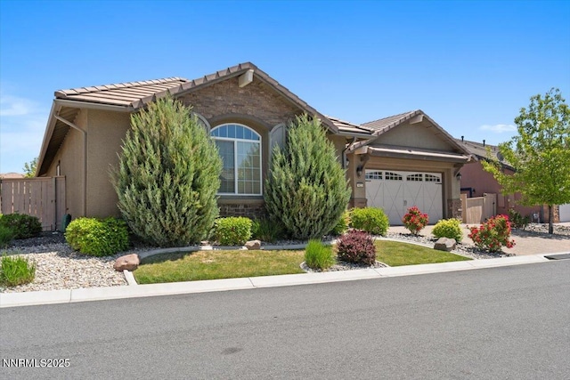 9822 Dyevera Ln, Reno, NV 89521 - view of front of home featuring a tile roof, an attached garage, stone siding, and stucco siding