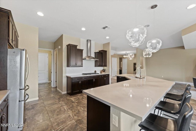 9822 Dyevera Ln, Reno, NV 89521 - kitchen with wall chimney range hood, freestanding refrigerator, a sink, gas stovetop, and a chandelier