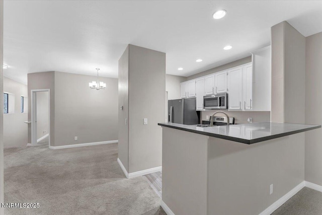 900 S Meadows Pkwy Unit 5222, Reno, NV 89521 - kitchen with appliances with stainless steel finishes, a peninsula, a chandelier, white cabinets, and light carpet
