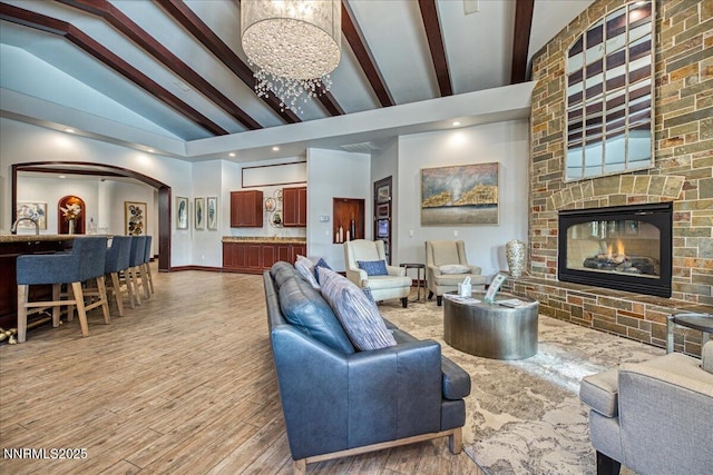 900 S Meadows Pkwy Unit 5222, Reno, NV 89521 - living room with arched walkways, beamed ceiling, a chandelier, a fireplace, and high vaulted ceiling