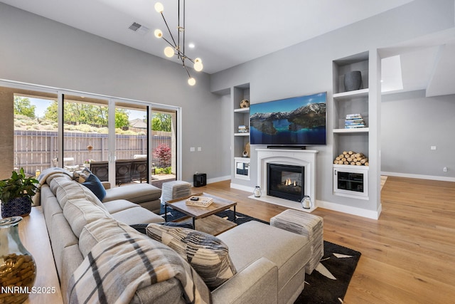 3060 Feathertop Dr, Reno, NV 89521 - living area with built in features, a fireplace with flush hearth, light wood-type flooring, and baseboards