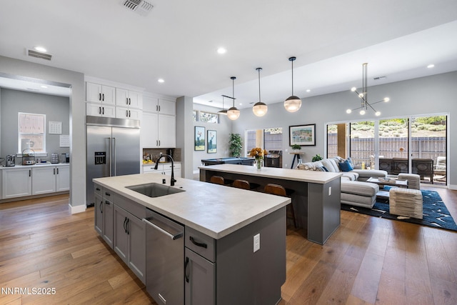 3060 Feathertop Dr, Reno, NV 89521 - kitchen featuring an island with sink, appliances with stainless steel finishes, a sink, recessed lighting, and wood-type flooring