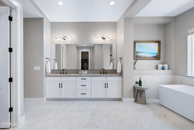 3060 Feathertop Dr, Reno, NV 89521 - full bathroom featuring marble look tile flooring, double vanity, a soaking tub, recessed lighting, and baseboards