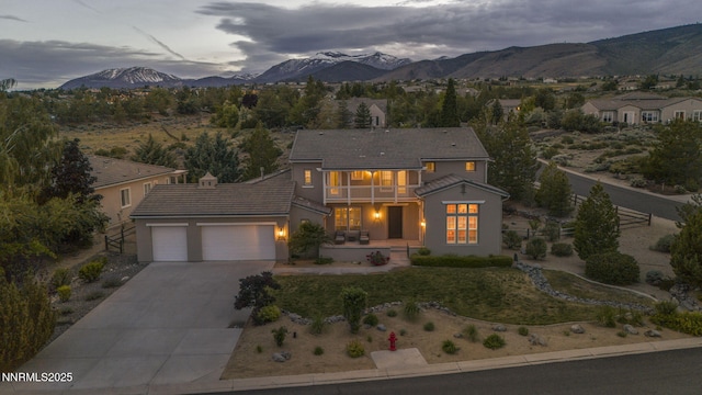 2965 Roundrock Ct, Reno, NV 89511 - view of front of house with a balcony, an attached garage, driveway, a mountain view, and a tile roof