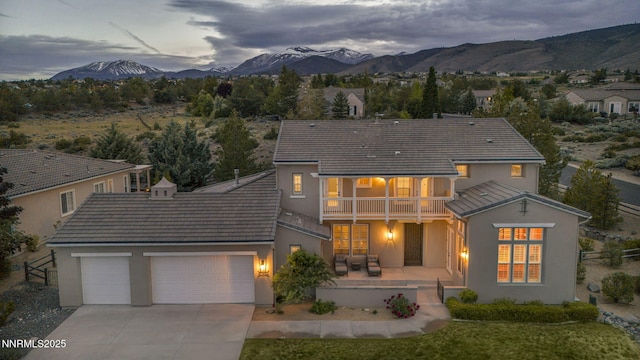 2965 Roundrock Ct, Reno, NV 89511 - back of property with a balcony, stucco siding, a tile roof, and a garage