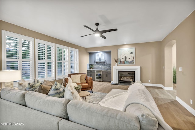 2965 Roundrock Ct, Reno, NV 89511 - living area featuring light wood-type flooring, baseboards, arched walkways, and a ceiling fan
