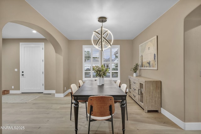 2965 Roundrock Ct, Reno, NV 89511 - dining space with arched walkways, a chandelier, baseboards, and light wood-type flooring