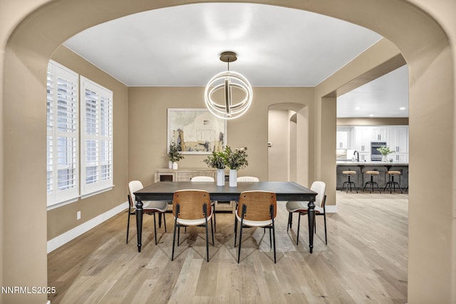 2965 Roundrock Ct, Reno, NV 89511 - dining space featuring arched walkways, baseboards, healthy amount of natural light, light wood-style flooring, and recessed lighting