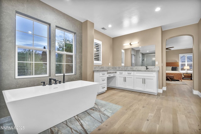 2965 Roundrock Ct, Reno, NV 89511 - bathroom featuring connected bathroom, hardwood / wood-style flooring, a freestanding tub, vanity, and a ceiling fan