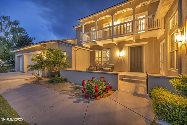 2965 Roundrock Ct, Reno, NV 89511 - view of front of property featuring a balcony, stucco siding, driveway, and an outdoor hangout area