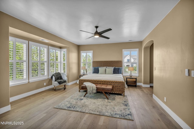 2965 Roundrock Ct, Reno, NV 89511 - bedroom with arched walkways, light wood finished floors, baseboards, and a ceiling fan