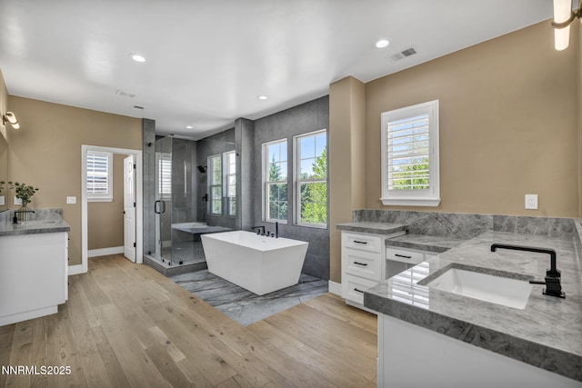2965 Roundrock Ct, Reno, NV 89511 - bathroom featuring vanity, a shower stall, a freestanding tub, wood finished floors, and baseboards