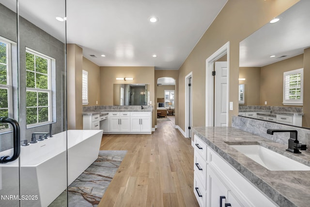 2965 Roundrock Ct, Reno, NV 89511 - full bathroom with a soaking tub, wood finished floors, recessed lighting, two vanities, and baseboards