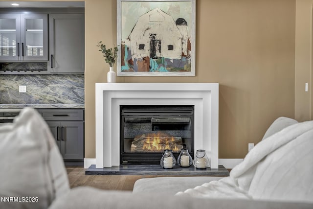 2965 Roundrock Ct, Reno, NV 89511 - detailed view of decorative backsplash, wood finished floors, a glass covered fireplace, and baseboards