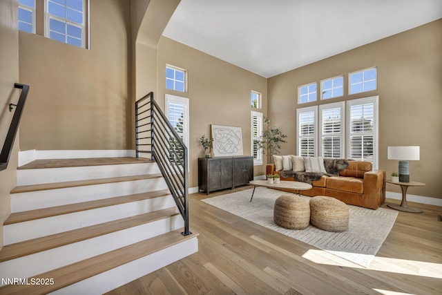 2965 Roundrock Ct, Reno, NV 89511 - living area with a towering ceiling, baseboards, stairway, wood finished floors, and arched walkways