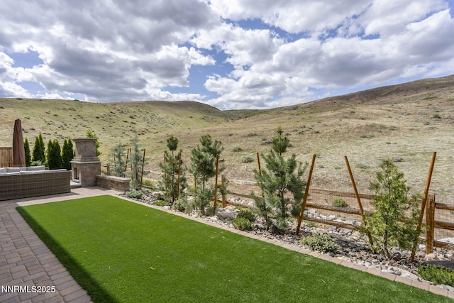 9129 Wild Skies Way, Reno, NV 89523 - view of yard featuring a mountain view, an outdoor living space with a fireplace, and a patio area