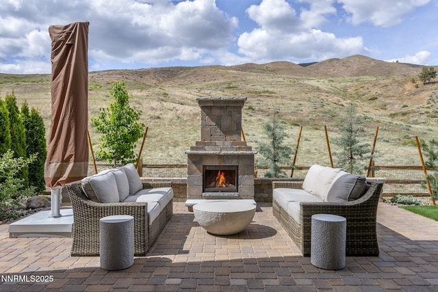 9129 Wild Skies Way, Reno, NV 89523 - view of patio with a mountain view and an outdoor living space with a fireplace